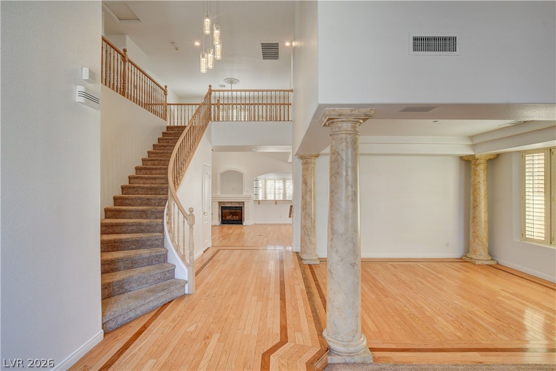 4354 Tall Tree Street Las Vegas, NV 89147 - Photo 6 of 67 This grand entrance features a sweeping staircase and elegant architectural columns, setting a tone of refined style.