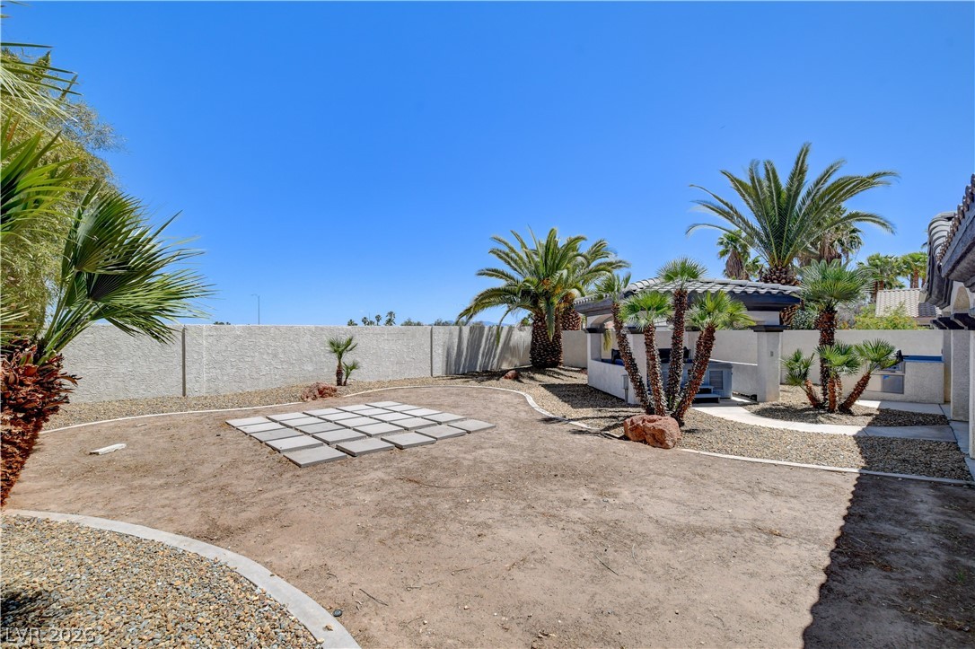 4354 Tall Tree Street Las Vegas, NV 89147 - Photo 62 of 67 This spacious yard offers a blank canvas for outdoor living, featuring a privacy wall and mature landscaping.