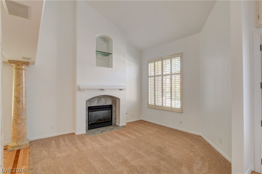 4354 Tall Tree Street Las Vegas, NV 89147 - Photo 7 of 67 This living area features a warm fireplace, a spacious window, and elegant architectural details.