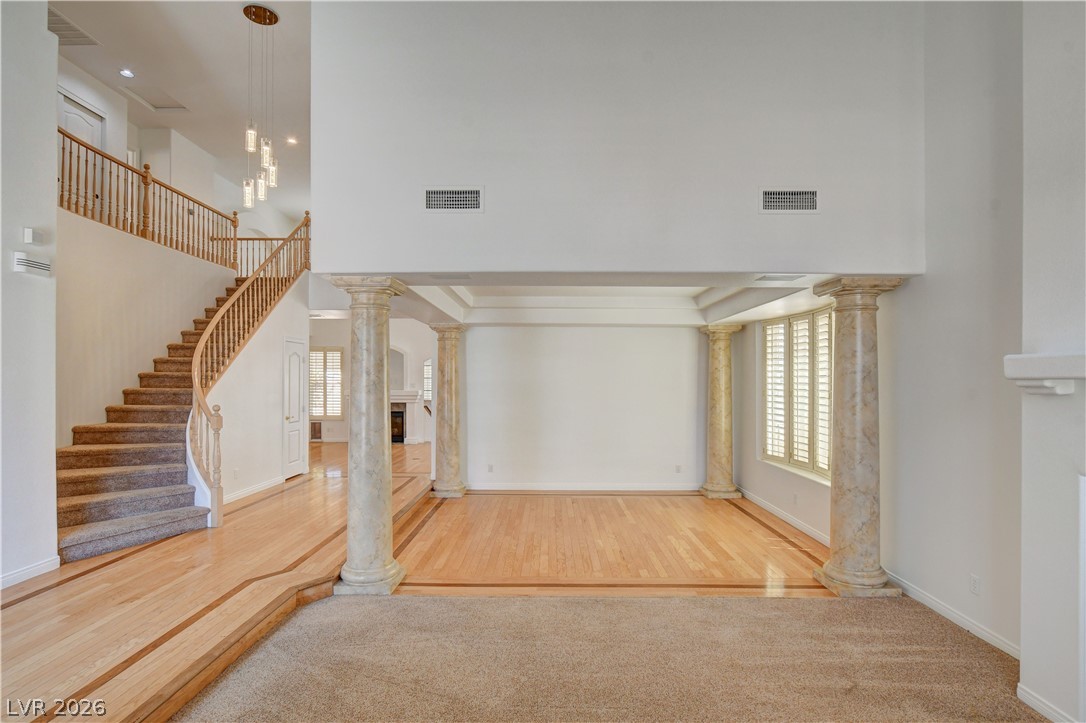 4354 Tall Tree Street Las Vegas, NV 89147 - Photo 9 of 67 This grand entrance showcases an elegant staircase and architectural columns, defining a spacious, light-filled interior.