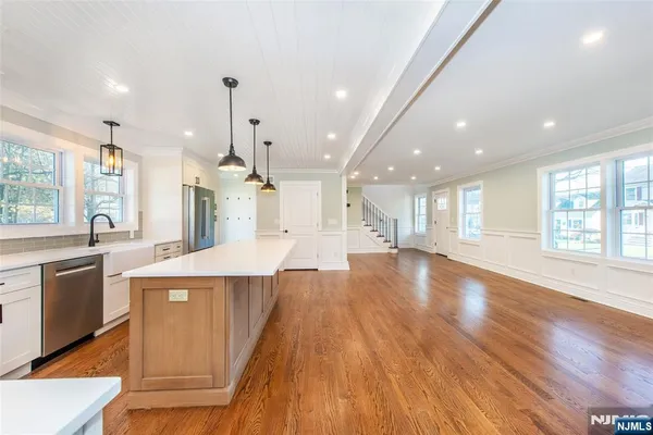 a large kitchen with stainless steel appliances a lot of counter space and a wooden floor