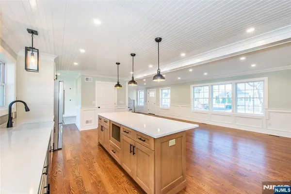 a large kitchen with stainless steel appliances a lot of counter space and a wooden floor