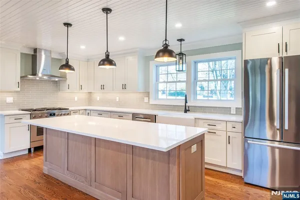 a large kitchen with granite countertop a large counter top and stainless steel appliances