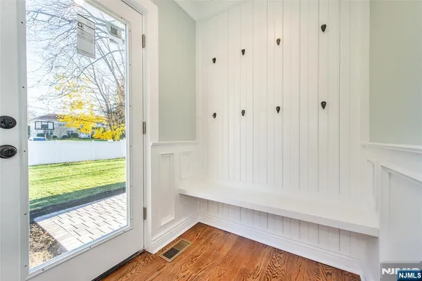 a view of empty room with wooden floor ceiling fan and kitchen view