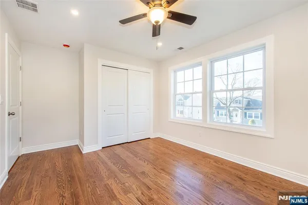 a view of a room with wooden floor and ceiling fan