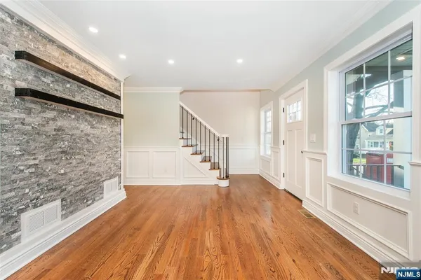 a large white kitchen with wooden floors and stainless steel appliances