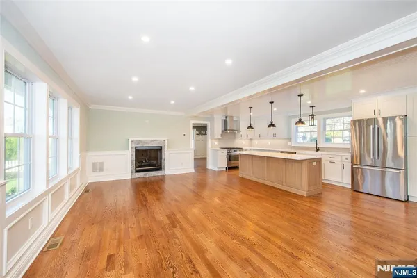 a large white kitchen with kitchen island a sink a stove and white cabinets