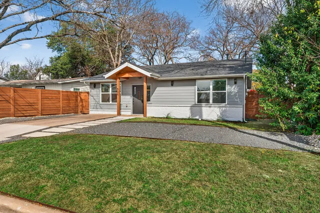 a front view of a house with a yard and trees