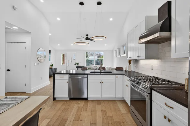 a kitchen with stainless steel appliances granite countertop a stove and a sink