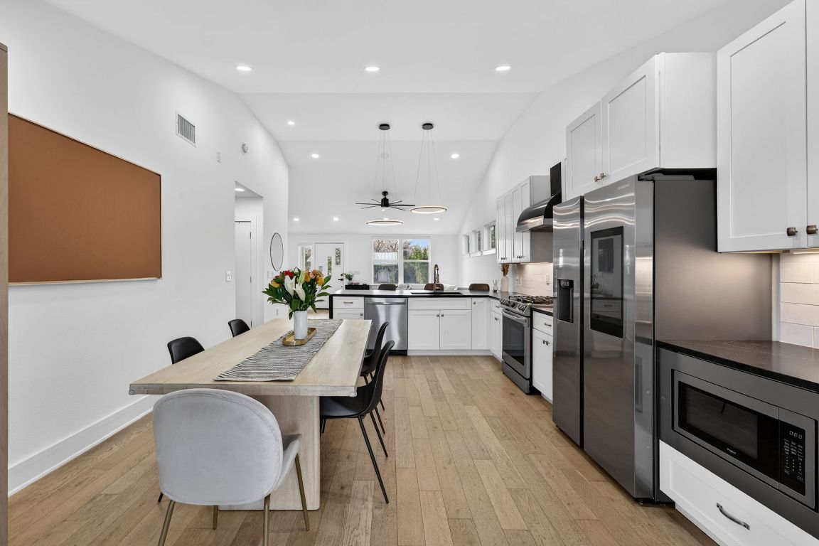 504 West Croslin Street Austin, TX 78752 - Photo 7 of 22 a kitchen with counter space a refrigerator and chairs