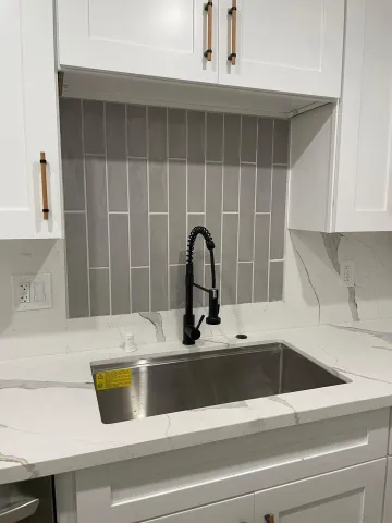 a close view of a sink and dishwasher with kitchen island