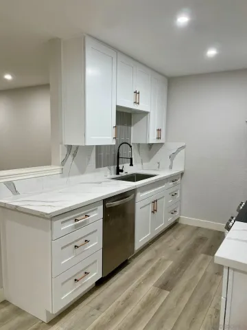 a kitchen with granite countertop a sink a stove and cabinets