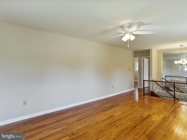 a view of an empty room with a chandelier fan