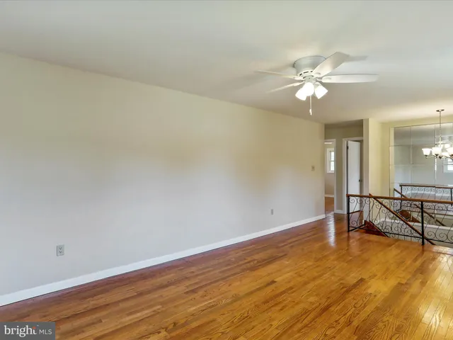 a view of an empty room with a chandelier fan