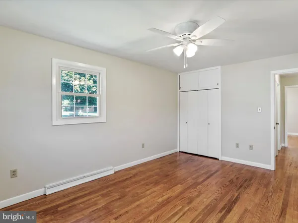 a view of a room with wooden floor and ceiling fan