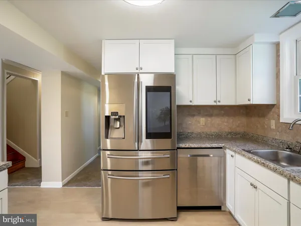 a kitchen with granite countertop a stove a refrigerator and a sink