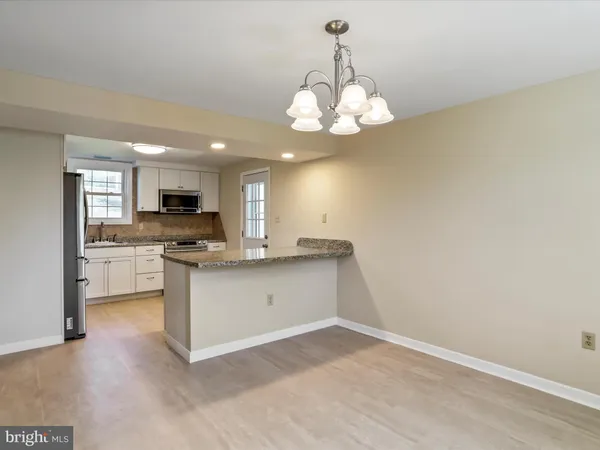 a kitchen with granite countertop a refrigerator and a sink