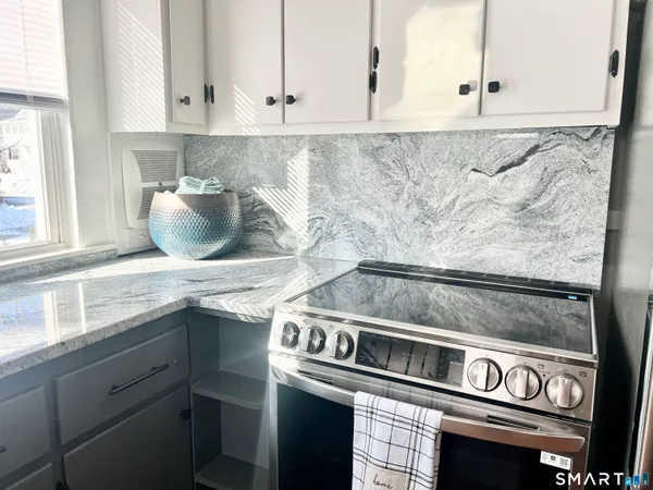 a kitchen with granite countertop a stove and a sink