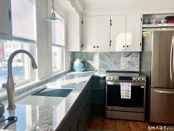 a kitchen with stainless steel appliances granite countertop a stove a refrigerator and a sink