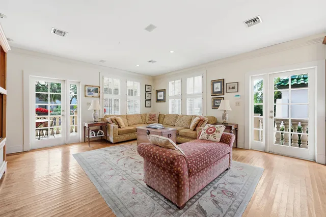 a kitchen with stainless steel appliances a stove a sink dishwasher a refrigerator and a dining table with wooden floor