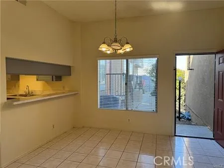 a dining room with chandelier and windows