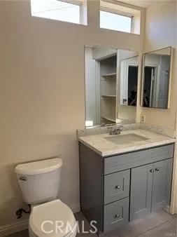 a bathroom with a granite countertop toilet sink and mirror