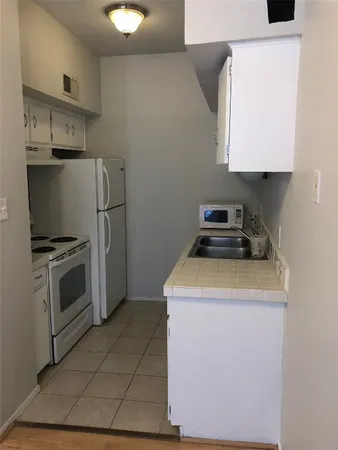 a kitchen with a stove top oven and cabinets