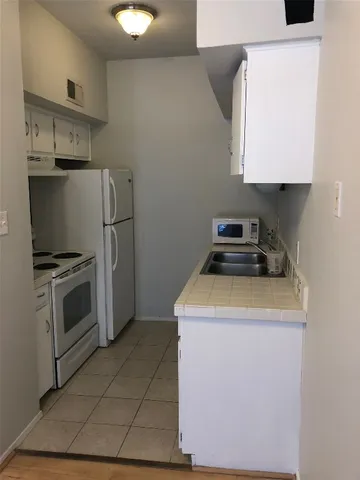 a kitchen with a stove top oven and cabinets