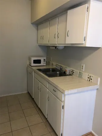 a kitchen with stainless steel appliances granite countertop a sink and a white cabinets
