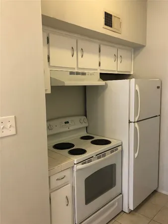 a kitchen with stainless steel appliances a stove and a refrigerator with white cabinets