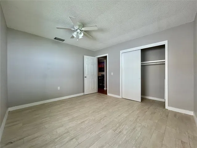 an empty room with closet and fan