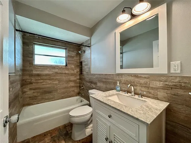 a bathroom with a granite countertop sink toilet and a bathtub