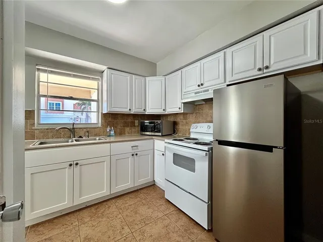 a white refrigerator freezer sitting inside of a kitchen