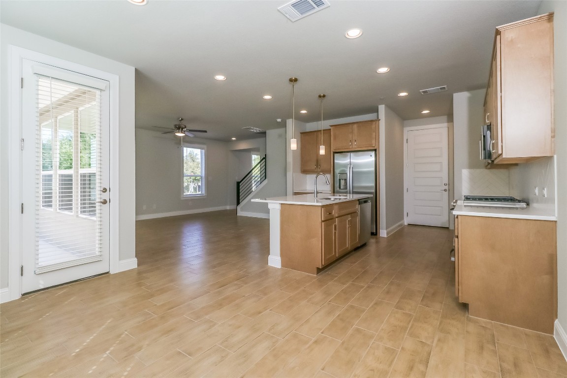 2605 Sam Bass Road, Unit 42 Round Rock, TX 78681 - Photo 25 of 27 a view of a kitchen with kitchen island a large counter top space a sink stainless steel appliances and cabinets