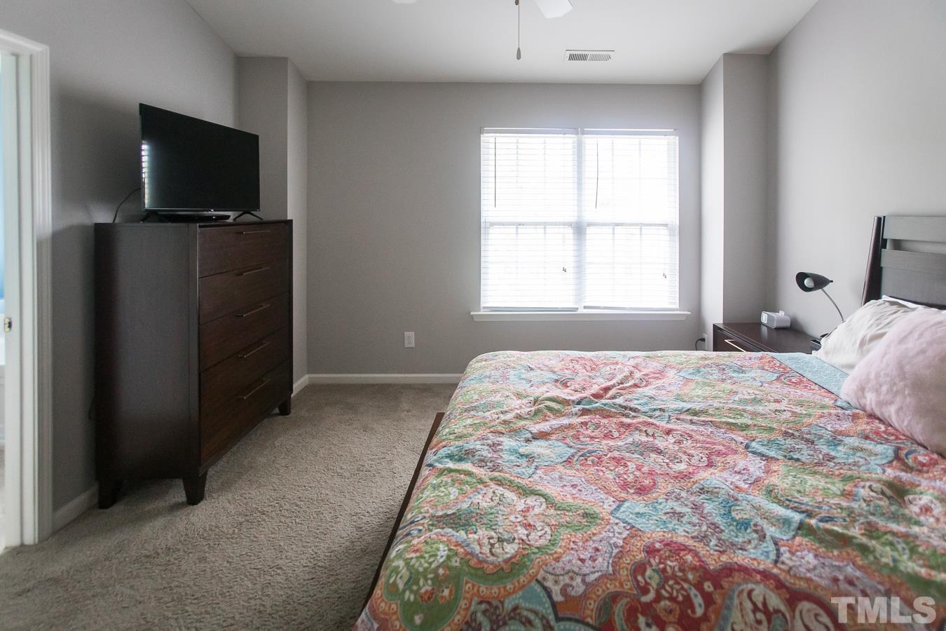 3137 Winding Waters Way Raleigh, NC 27614 - Photo 22 of 54 a bedroom with a bed and a flat screen tv