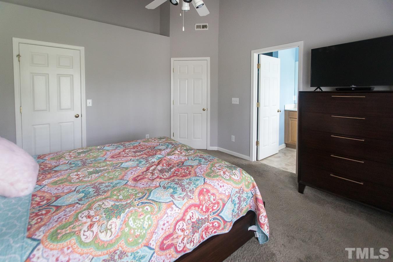 3137 Winding Waters Way Raleigh, NC 27614 - Photo 24 of 54 a bedroom with a bed and a flat tv screen on dresser