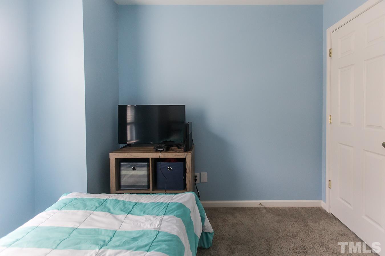 3137 Winding Waters Way Raleigh, NC 27614 - Photo 34 of 54 a bedroom with a bed and a flat screen tv