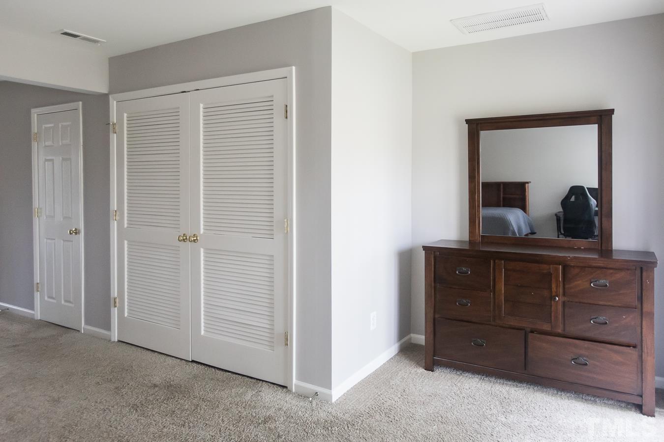 3137 Winding Waters Way Raleigh, NC 27614 - Photo 39 of 54 a bedroom with a dresser and a mirror