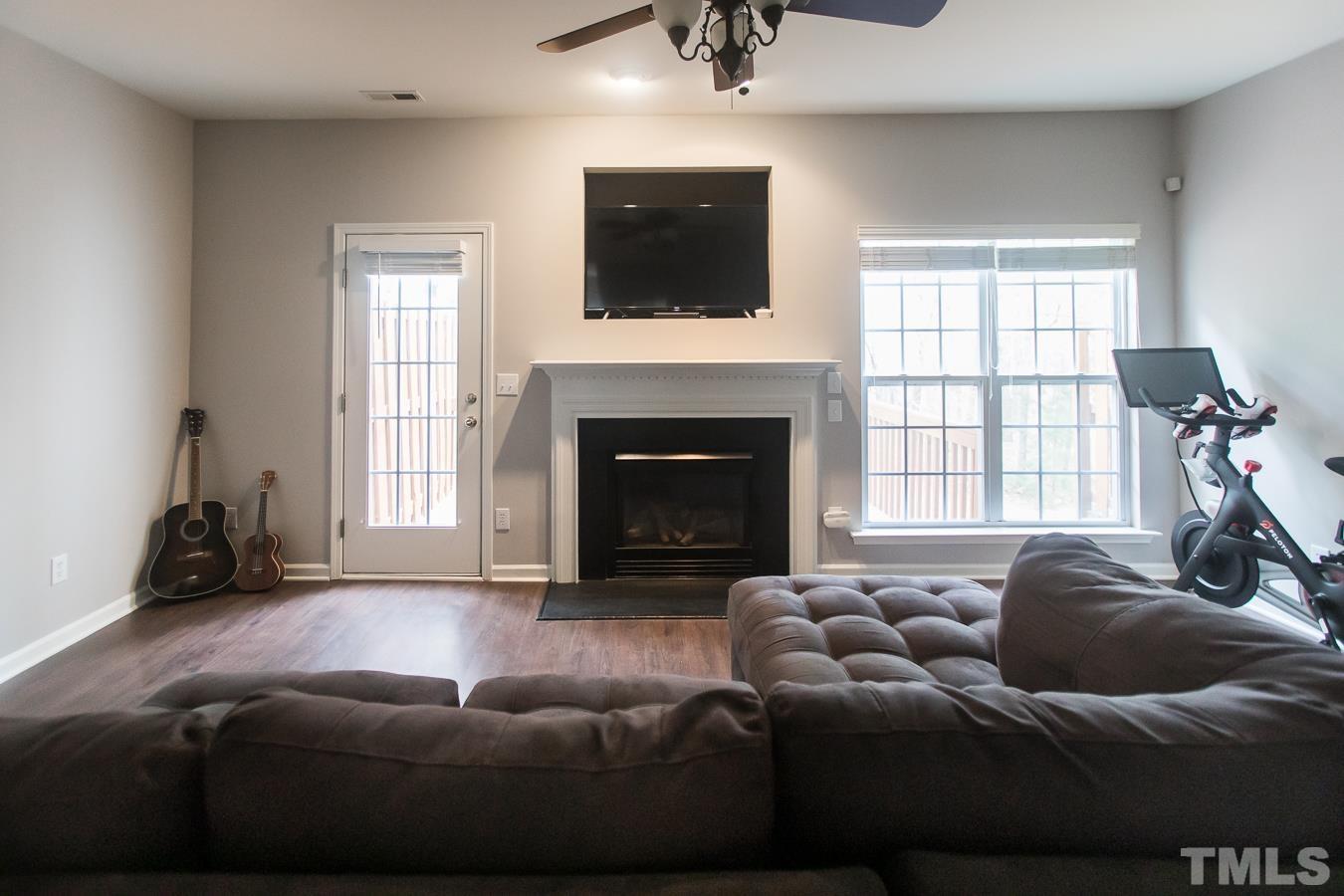 3137 Winding Waters Way Raleigh, NC 27614 - Photo 6 of 54 a living room with furniture a flat screen tv and a fireplace