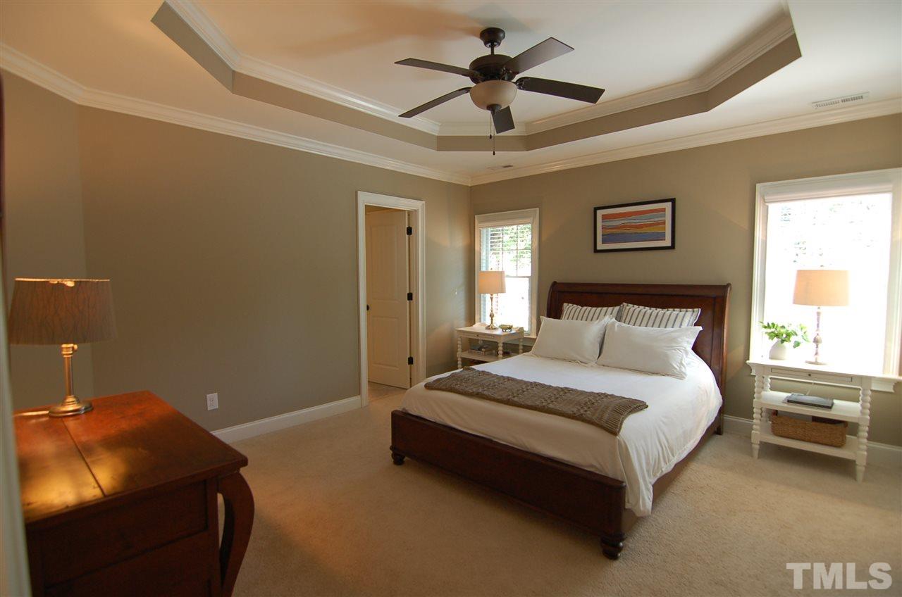 616 New Road Raleigh, NC 27608 - Photo 12 of 25 a spacious bedroom with a bed and a chandelier