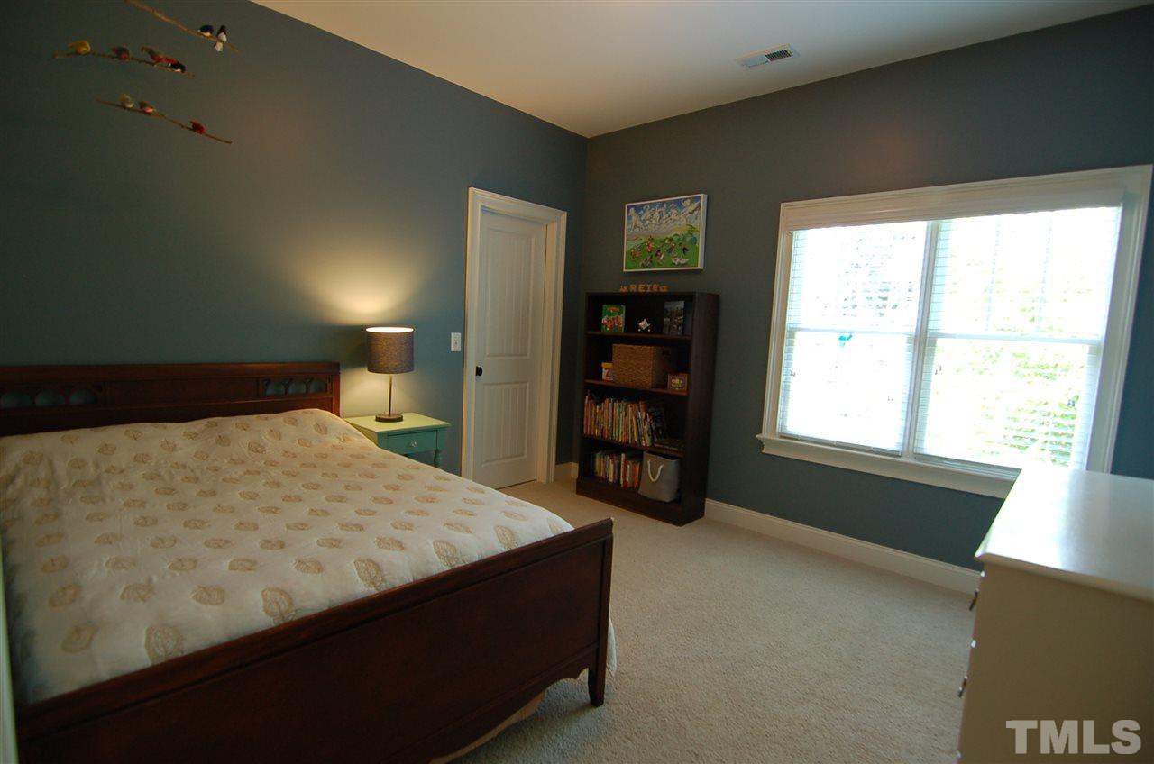 616 New Road Raleigh, NC 27608 - Photo 16 of 25 a bed sitting in a bedroom next to a window