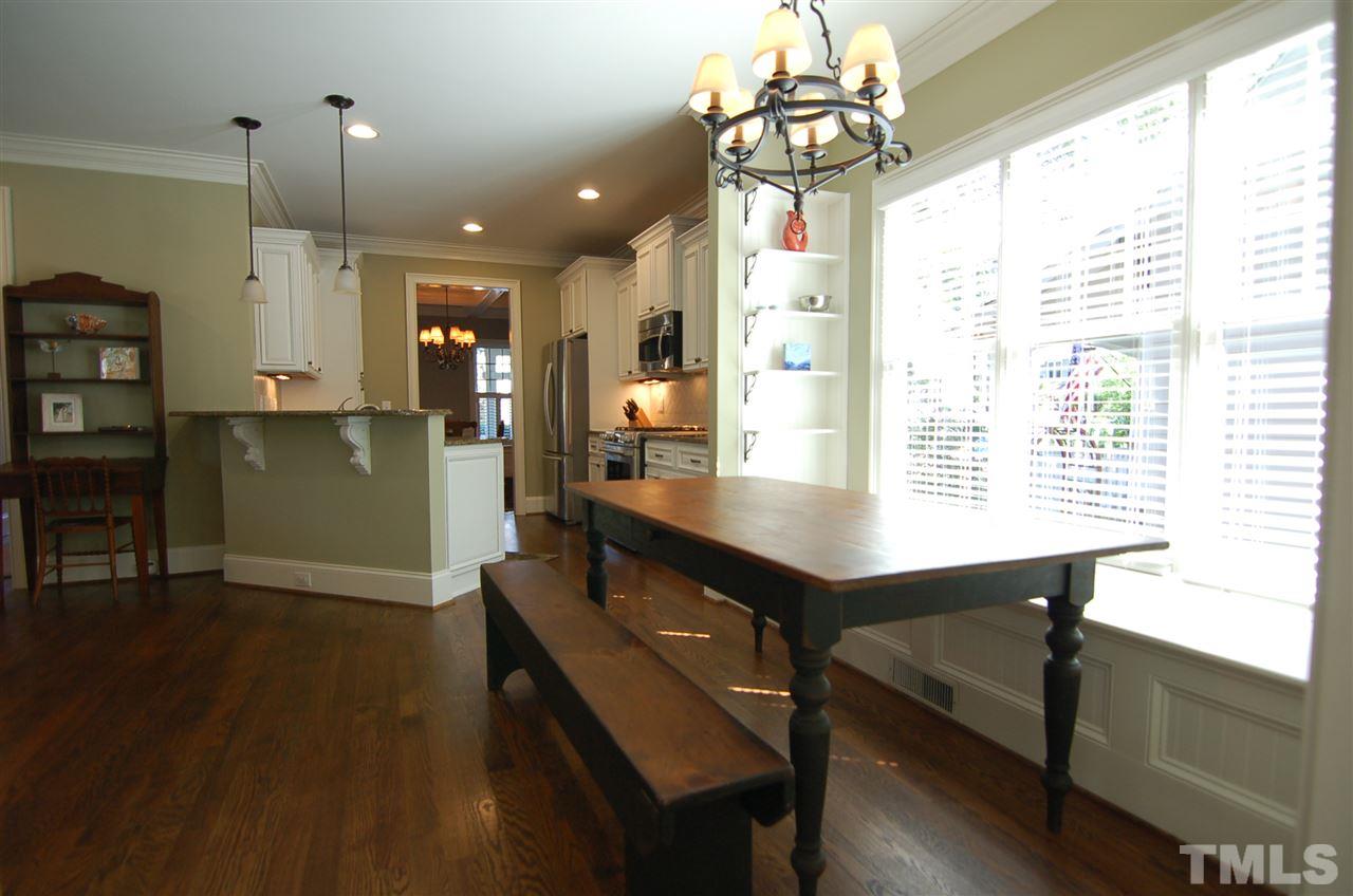 616 New Road Raleigh, NC 27608 - Photo 8 of 25 a kitchen with a table chairs and wooden floor