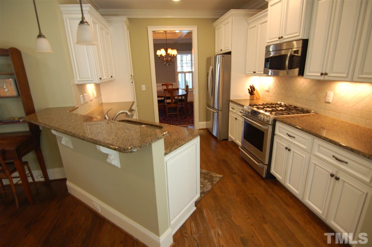 616 New Road Raleigh, NC 27608 - Photo 9 of 25 a kitchen with stainless steel appliances granite countertop a stove a sink and a refrigerator