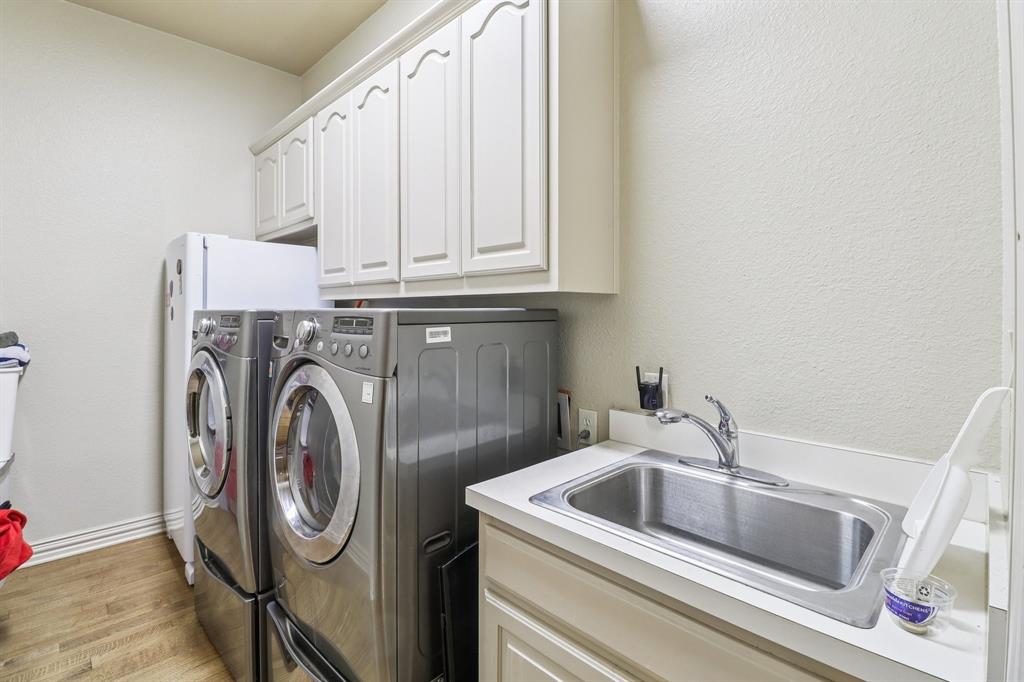 219 High Point Drive Murphy, TX 75094 - Photo 20 of 30 Laundry room with cabinets and a sink for added convenience.