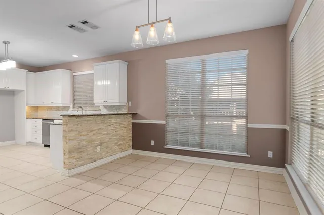 a view of kitchen with granite countertop cabinets and window
