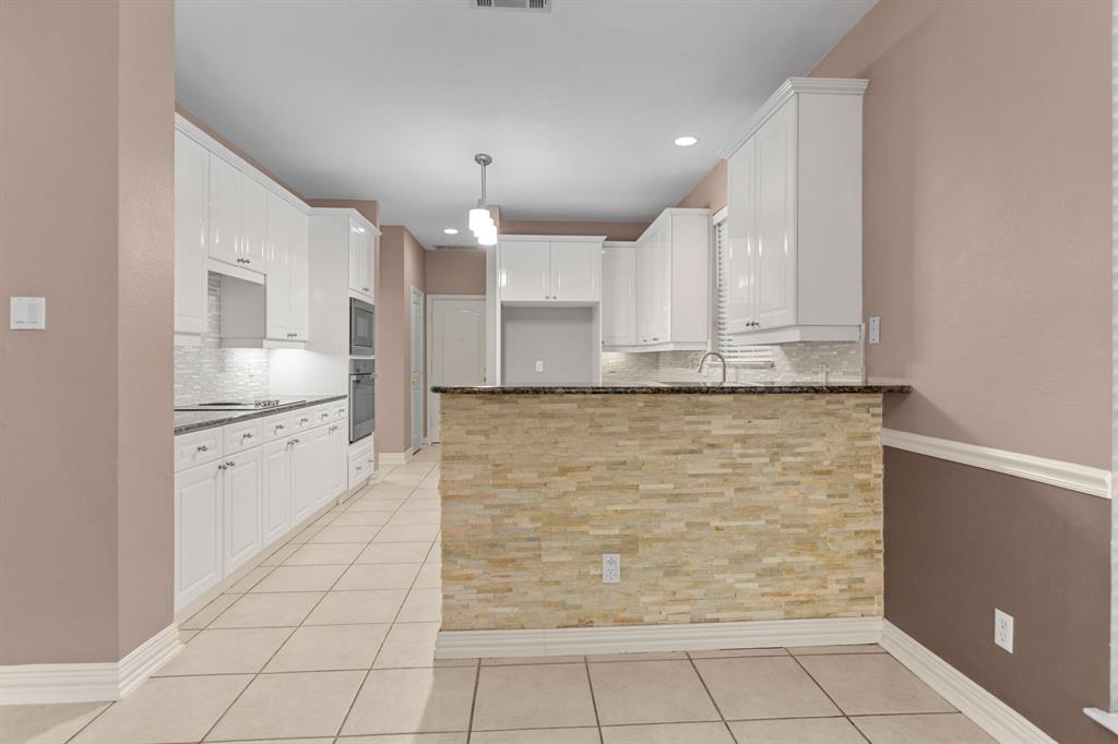2 Shields Court Trophy Club, TX 76262 - Photo 15 of 39 a large white kitchen with kitchen island granite countertop a sink and cabinets