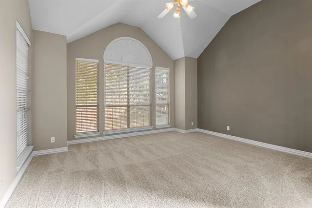 an empty room with chandelier fan