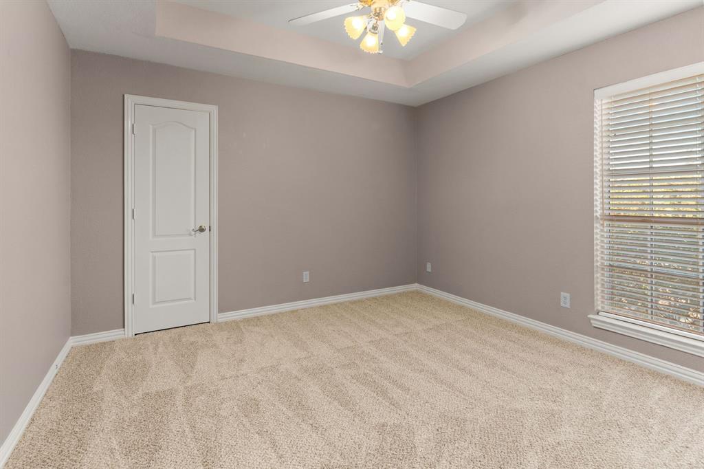 2 Shields Court Trophy Club, TX 76262 - Photo 31 of 39 an empty room with a chandelier fan and windows