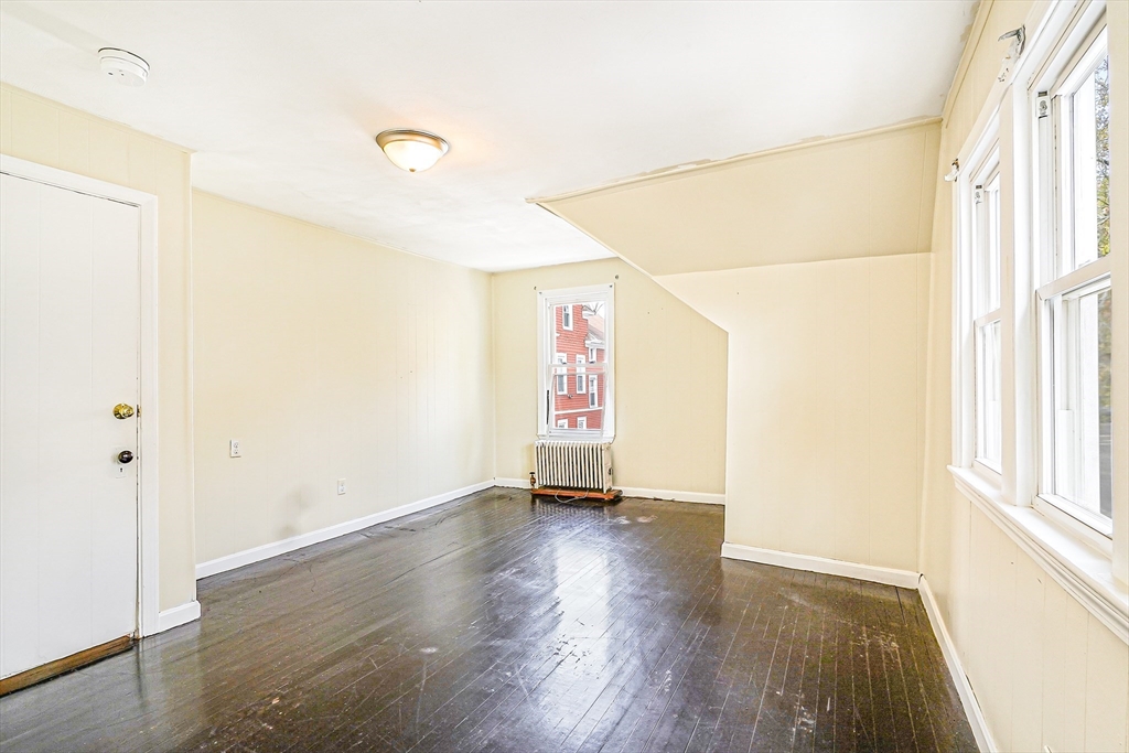 18 Sycamore Street Springfield, MA 01109 - Photo 14 of 22 a view of an empty room with wooden floor and a window
