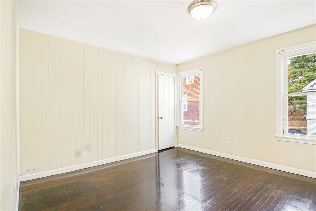 18 Sycamore Street Springfield, MA 01109 - Photo 15 of 22 an empty room with wooden floor and windows